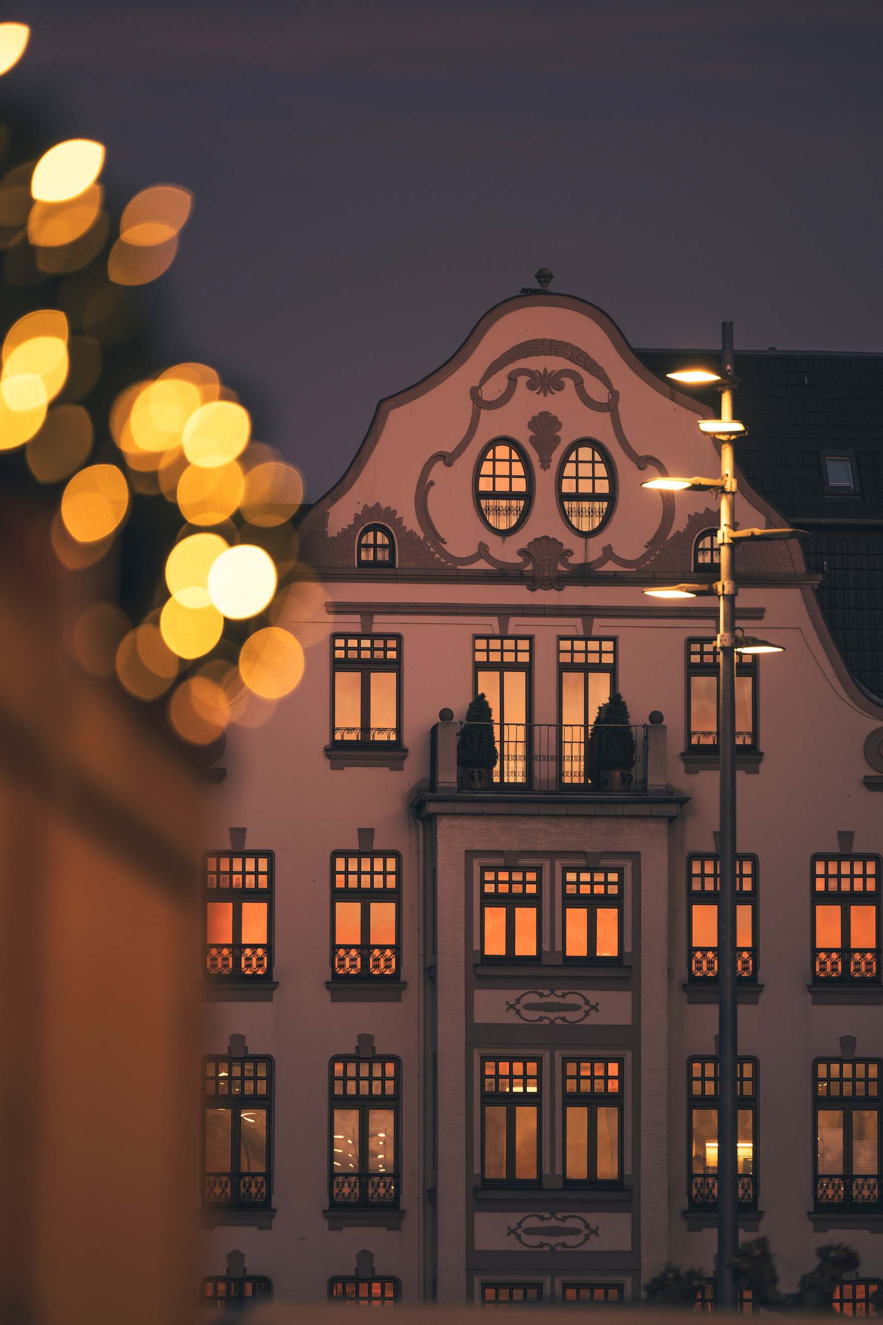 Historisches Gebäude in Düsseldorf in der Dämmerung mit erleuchteten Fenstern